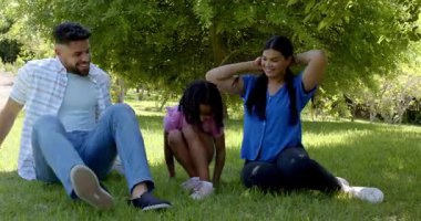 Aile, güneşli bir günde dışarıda kahkaha atmaktan ve kaynaşmaktan zevk alır. Mutluluk, birliktelik, yaşam tarzı, rahatlık.