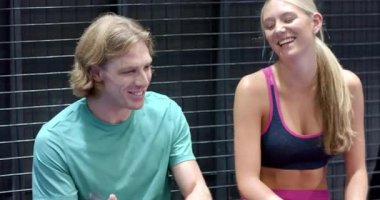 Spor giyimli iki kişi kapalı sahada Padel tenis maçından sonra mutlu bir şekilde sohbet ediyorlar. spor, arkadaşlık, sohbet, etkinlik, mutluluk, eğlence