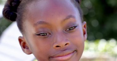 Bahçedeki genç kız düşünceli görünüyor, bahçede güneşli bir günün tadını çıkarıyor. Doğa, güneş ışığı, tefekkür, dinginlik, sükunet, rahatlama.