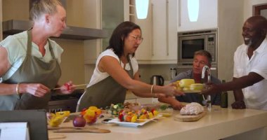 Mutfakta çeşitli kadınlar taze sebzeler hazırlıyor, evde birlikte yemek pişirmekten zevk alıyorlar. Mutfak, arkadaşlık, hazırlık, takım çalışması, yaşam tarzı, sağlıklı beslenme