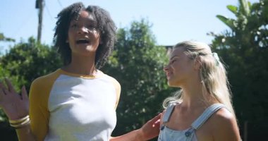 Güneşli bir günde havuz başında sohbet eden iki bayan arkadaş. Arkadaşlık, yaz, rahatlama, boş zaman, tatil, su