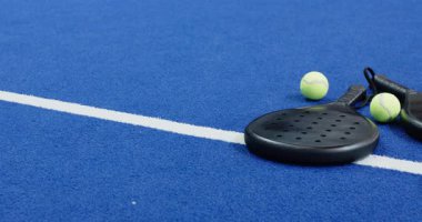 Padel raketler ve toplar mavi sahada heyecan verici maça hazır, kopyalama alanı. Spor, ekipman, eğlence, rekabet, eğlence, atletizm