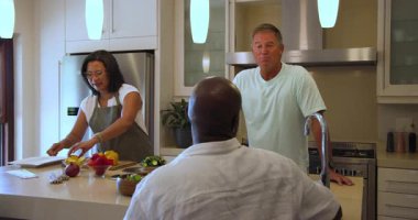 Farklı yaşlılar mutfakta birlikte yemek pişiriyor, sebze hazırlıyor ve evde sohbetin tadını çıkarıyor. Arkadaşlık, yemek hazırlama, takım çalışması, aşçılık, etkileşim