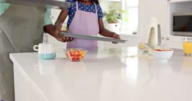 Afro-Amerikan, baba-kız, parlak mutfakta birlikte ev yapımı pizza yapıyorlar. Aile, yemek pişirme, kaynaşma, aşçılık, ebeveynlik, pişirme