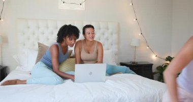 Yatakta tablet ve dizüstü bilgisayar kullanan çeşitli bayan arkadaşlar, fikirleri paylaşıyorlar. Arkadaşlık, takım çalışması, işbirliği, teknoloji, beyin fırtınası, eğlence.