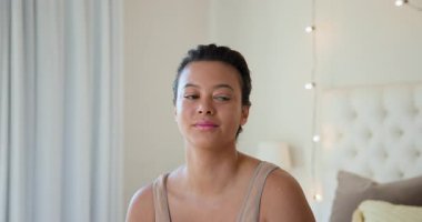 İçerde dinlenen genç bir kadın, arka planda hafif ışıklandırmayla düşünceli görünüyor. Düşünce, içgözlem, dinginlik, sükunet, farkındalık, rahatlık