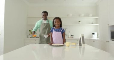 Afro-Amerikan, baba ve kızı mutfakta birlikte yemek hazırlıyor, kaliteli zaman geçiriyor. Aile, yemek pişirme, bağ kurma, ebeveynlik, ev hayatı, yemek hazırlama