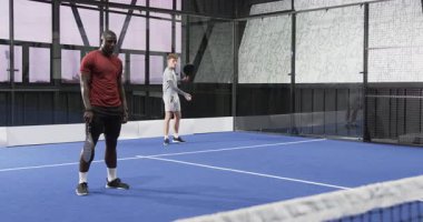 İki farklı adam kapalı alanda tenis oynuyor, odaklanmışlar ve harekete geçmeye hazırlar. Spor, raket, atletizm, rekabet, aktif, takım çalışması