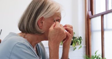 Son sınıf öğrencisi kadın evde göz bandı takıyor, kendine bakım rutinine odaklanıyor. Sağlık, cilt bakımı, güzellik, şımartma, rahatlama, yaşlılık.