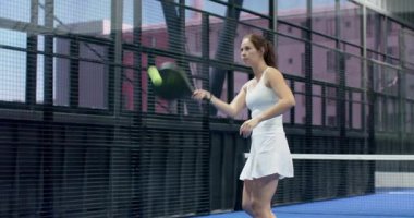 Padel tenisi oynayan kadın, hızla iç sahaya gidiyor, oyuna odaklanıyor. Spor, atletizm, raket, rekabet, egzersiz, fitness