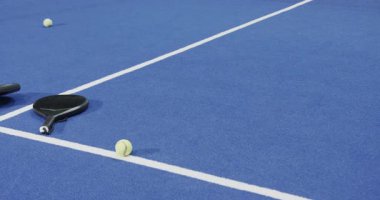 Padel raketler ve toplar mavi sahaya saçılmış, oyun için hazır, kopyalama alanı. Spor, atletizm, ekipman, eğlence, eğlence, spor, spor