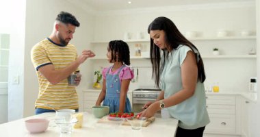 Aile taze meyve salatası hazırlıyor. Parlak mutfakta, kaliteli zaman geçirmenin tadını çıkarıyorlar. Yemek pişirme, birliktelik, sağlıklı yeme, bağlanma, mutluluk, beslenme