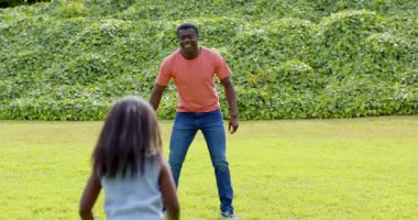 Afro-Amerikalı, baba-kız güneşli parkta yakalamaca oynuyor, açık havada eğleniyorlar. Aile, kaynaşma, eğlence, açık hava, boş zaman, şakacı