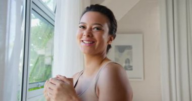 Pencere kenarında kahvesini yudumlayan bir kadın, rahatlatıcı ve huzurlu bir sabah anı yaşıyor. Rahatlama, sakinlik, yaşam tarzı, dinginlik, farkındalık.