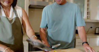 Üst düzey bir çift mutfakta birlikte yemek hazırlıyor, evde taze sebze doğruyor. Aşçılık, malzemeler, yaşlılar, sağlıklı beslenme, aşçılık, yaşam tarzı