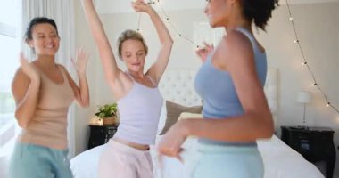 Neşeli bir şekilde dans eden, çeşitli bayan arkadaşlar yatak odasında, evde kaygısız anları kutluyorlar. Kutlama, mutluluk, birliktelik, neşe