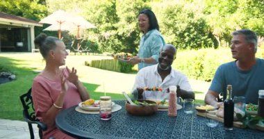 Bahçe barbeküsünde eğlenen kıdemli çift renkli şiş ve mısır servis ediyorlar. Izgara, bahçede yemek, yaz, yaşlılar, toplanma, kutlama