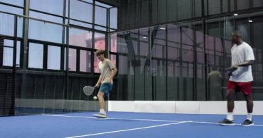 Kapalı sahada Padel tenis oynamaya odaklanmış sporcu servise hazırlanıyor. spor, rekabet, raket, hazırlık, konsantrasyon, fitness