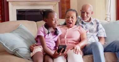 Birlikte gülerdik, farklı büyükbabalar ve çocuklar evdeki kanepede akıllı telefona bakarlardı. Aile, bağ, teknoloji, çok nesilli, mutluluk, konforlu