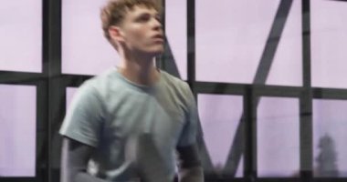 Kapalı alanda tenis oynayan genç bir adam raket tutuyor ve odaklanmış görünüyor. Spor, egzersiz, yarışma, atlet, konsantrasyon, padeltennis