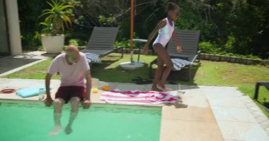 Bahçedeki şezlongda oturmak, büyükannenin çocuğu pembe havluya sarması. Aile, bağ, birliktelik, rahatlama, şefkat, eğlence.