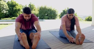 Çift güvertede yoga egzersizleri yapıyor, esneklik ve gevşemeye odaklanıyor. Meditasyon, sağlık, fitness, egzersiz, farkındalık, yaşam tarzı