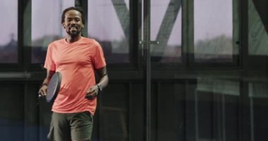 Padel tenisi oynayan atletik bir adam, kapalı sahada topa vurmaya odaklanıyor. spor, fitness, action, racquet, competition, player