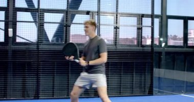 Padel 'in üzerinde yürüyen iki farklı adam ellerinde raketler, maç için hazırlar. Spor, fitness, yarışma, takım çalışması, egzersiz, eğlence