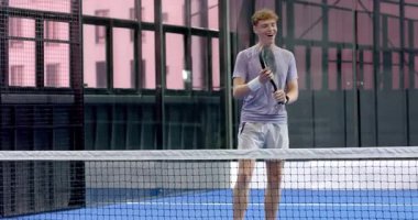 Padel tenis kortunda zaferi kutlayan iki farklı adam beşlik çaktı. Spor, kutlama, çeşitli arkadaşlar, takım çalışması, rekabet, raket