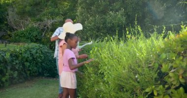 Bahçede birlikte bahçeler, güneşli bir günde torunlarıyla çeşitli büyükbabalar ekiyorlar. Aile, bağ, çok nesilli, doğa, takım çalışması