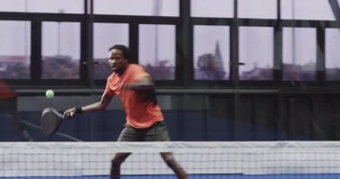 Çeşitli oyuncular kapalı sahada Padel tenis maçının keyfini çıkarıyorlar, heyecan gösteriyorlar. Spor, takım çalışması, sporcular, yarışma, raket, eğlence