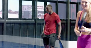 Padel tenisi oynayan atletik bir adam, kapalı sahada topa vurmaya odaklanıyor. Spor, egzersiz, raket, rekabet, konsantrasyon, atlet