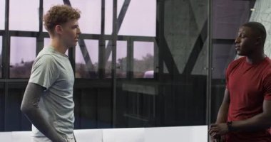 Mavi padel kapalı sahadaki oyuncular maç için hazırlanıyor, spor ayakkabıları giyiyorlar. Spor, raket sporu, rekabet, takım çalışması, aktif yaşam tarzı, ayakkabı