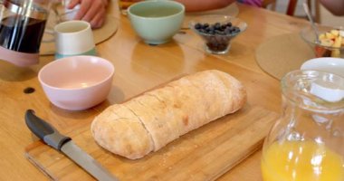 Aile birlikte kahvaltı yapıyor, kahve dolduruyor ve taze meyve paylaşıyor. Bağlanma, birliktelik, sabah, yemek