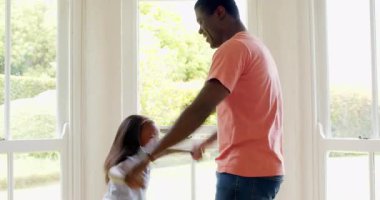 Afro-Amerikalı, baba ve kızı evde neşeyle dans ediyor, birlikte neşeli anlar paylaşıyorlar. Aile, bağ, mutluluk, ebeveynlik, babalık, yaşam tarzı