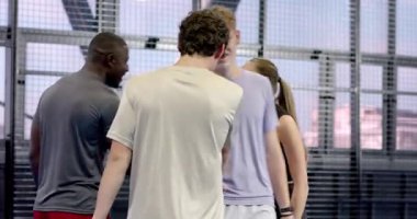 Padel tenis oynayan, gülümseyen ve kapalı sahada raket tutan bir grup arkadaş. Spor, raket, etkinlik, fitness, raket, takım çalışması