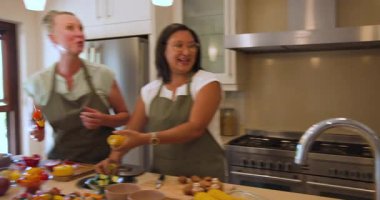 Mutfakta yemek hazırlayan ve evde sohbetin tadını çıkaran bir grup arkadaş. Yemek pişirme, toplama, sosyalleşme, yemek hazırlama, çeşitlilik, takım çalışması