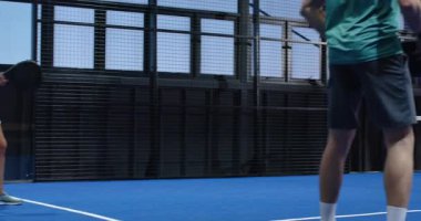 Padel tenis oynayan, gülümseyen ve elinde raket tutan bir kadın. Spor, enerji, spor, açık hava, boş zaman, atletik