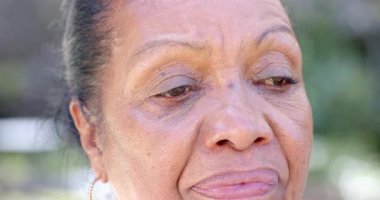 Bahçedeki yaşlı kadın düşünceli görünüyor, doğada huzurlu bir anın tadını çıkarıyor. Son sınıf, tefekkür, sükunet, sükunet, altın yıllar.