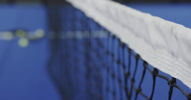 Padel tenis kortu, raketler ve toplar mavi yüzeyde, oyuna hazır. Spor, fitness, eğlence, ekipman, raket, eğlence