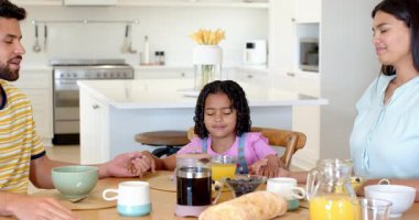 Aile evde kahvaltıda el ele tutuşup gülümsüyor, birliktelikten zevk alıyor. Bağ, birlik, mutluluk, yemek, sabah, uyum