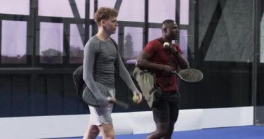 Oyuncular mavi iç sahada yapılacak Padel tenis maçına hazırlanıyor, ellerinde raketler var. spor, takım çalışması, yarışma, egzersiz, spor, raket