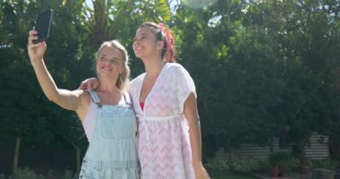 Dışarıdaki iki bayan arkadaş akıllı telefona bakarken aynı heyecanı paylaşıyorlar. communication, technology, happiness, life style, link