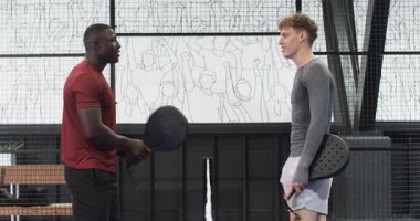 İki farklı adam kapalı alanda tenis oynuyor, kapalı sahada oyunun ve rekabetin tadını çıkarıyorlar. spor, atletik, takım çalışması, eğlence, egzersiz