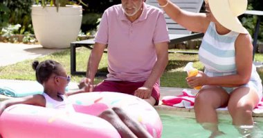 Farklı büyükbabalar havuz başında güneşli bir günün tadını çıkarıyorlar. Torunlarıyla şakalaşıyorlar. Aile, kaynaşma, boş zaman, yaz, rahatlama, çok nesilli