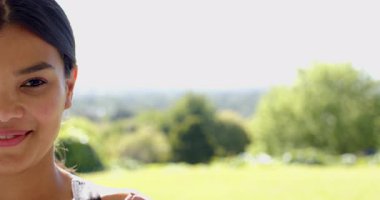 Güler yüzlü kız yemyeşil parkta güneşli bir günün tadını çıkarıyor, açık havada neşeli hissediyor, fotokopi çekiyor. Mutluluk, doğa, rahatlık, rahatlama, yaz, çimen.