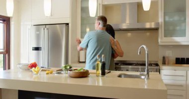 Modern mutfakta kucaklaşan kıdemli çift, evde birlikte sabahın tadını çıkarıyorlar. Yaşlılar, yaşam tarzı, sevgi, aile, birliktelik.