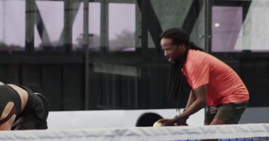 Kapalı sahada Padel tenis oynayan adam topa kürekle vurmaya odaklanıyor. Sporcu, müsabaka, raket, spor, oyun, kararlılık