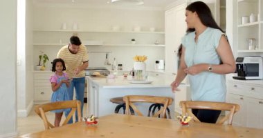 Aile mutfakta kahvaltıdan keyif alıyor, gülümsüyor ve taze ekmek servis ediyor. Bağlanma, sabah