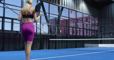 Kapalı alanda tenis oynayan bir adam, kapalı alanda mavi kortta raketle topa vuruyor. spor, atletik, eğlence, rekabet, aksiyon, eğlence